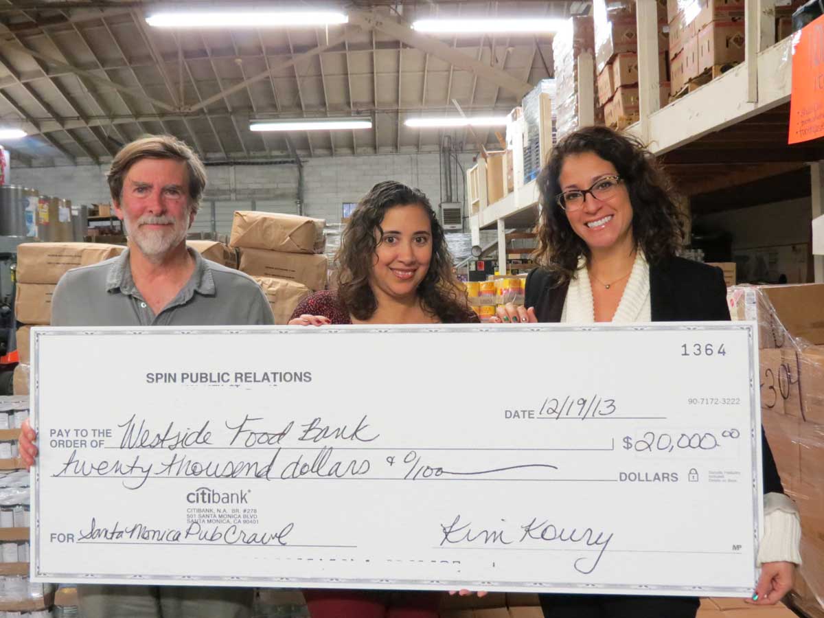 Kim Koury(right), president ofSanta Monica-based Spin PR, presents a check for $20,000 to the Westside Food Bank. The money was raised as part of the SANTA Monica Pub Crawl. (Photo courtesy Spin PR)