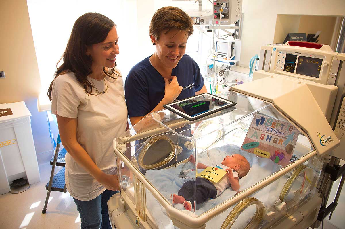 NEAT: Helen Cox and nurse Sanna Howell use the ‘I See U Baby iPad' to show grandparents in England newborn Asher. (Photo courtesy Tom Neerken)