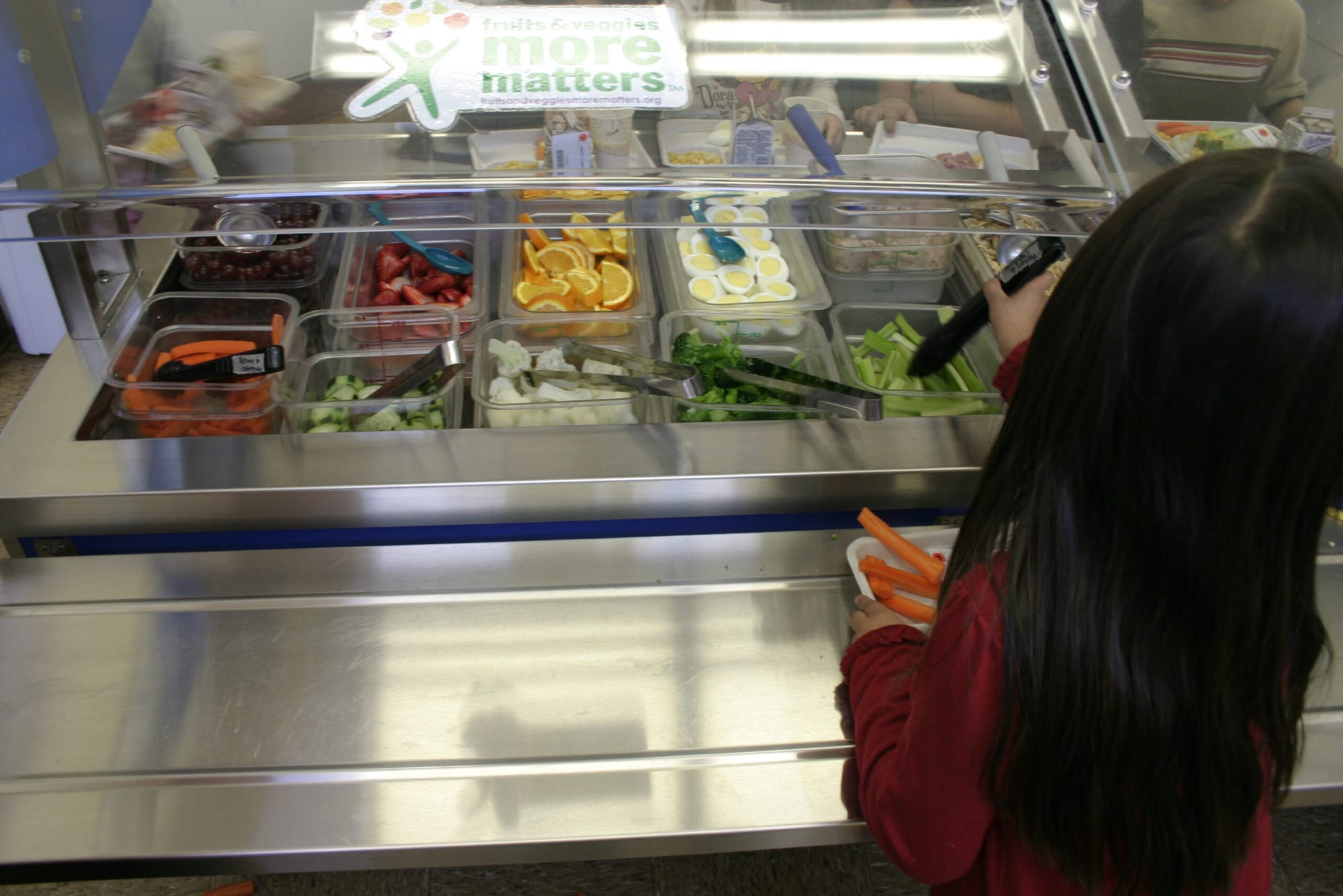 In this photo from last year a student at Will Rogers Elementary School grabs some celery sticks from the salad bar, which is stocked mostly with food purchased at one of the Santa Monica Farmers' Markets. 