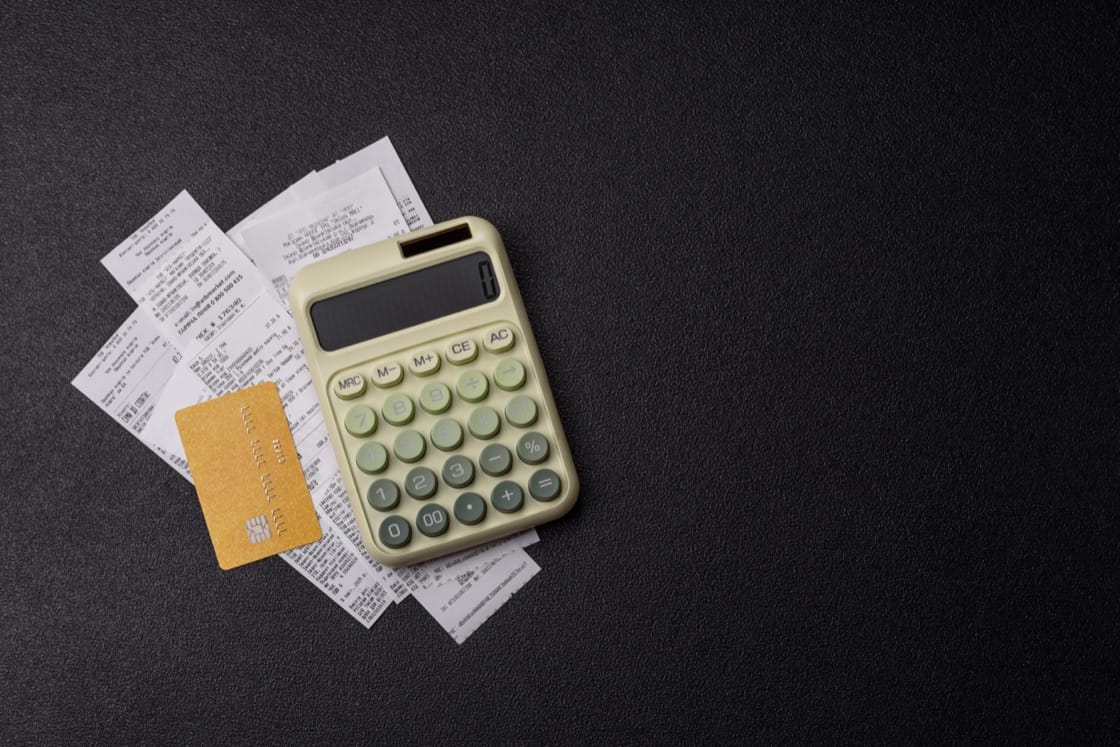 Calculator, receipt and credit card on black