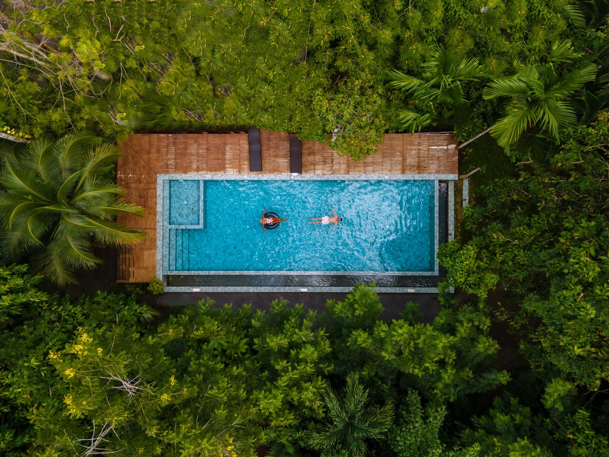 Aerial view of swimming pool in the jungle of Krabi Thailand, couple in pool, men and woman in pool