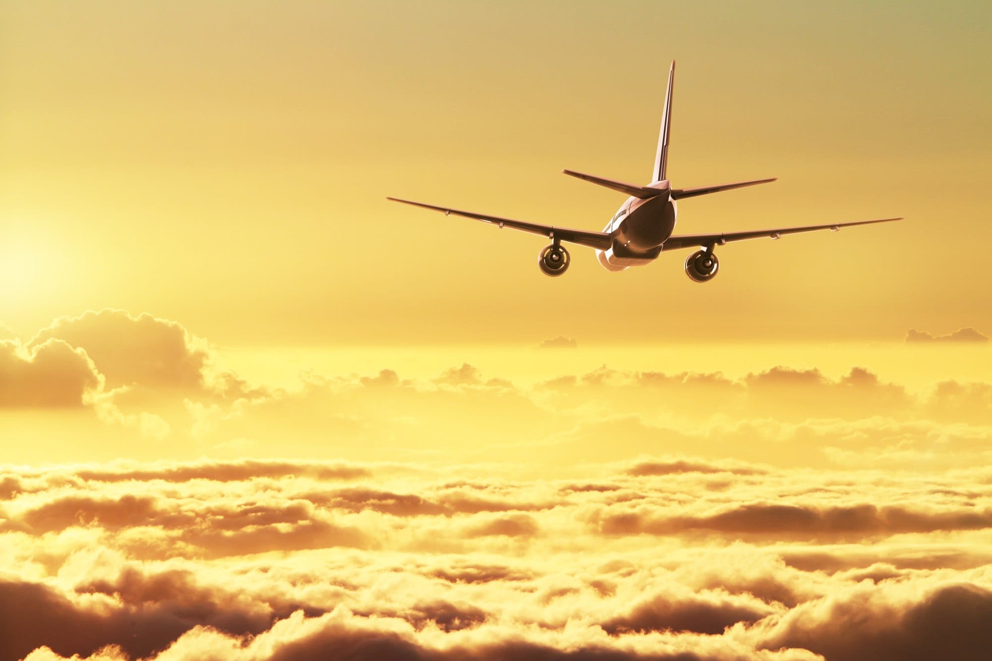 Airplane Flying Above Clouds at Sunset