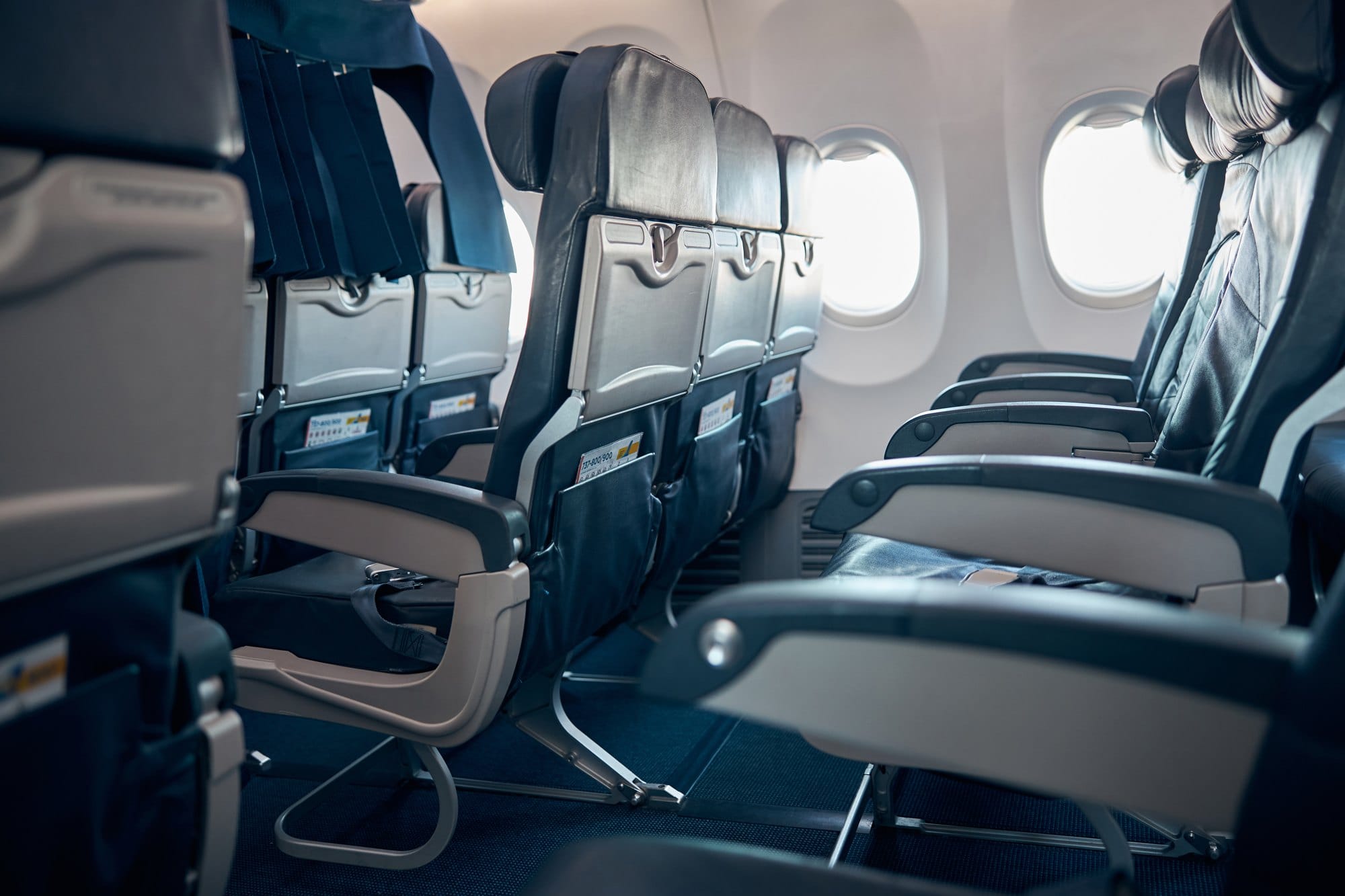 Airplane Interior with Empty Seats and Blue Carpet