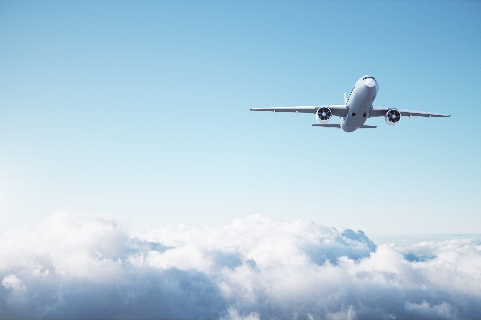 Airplane Flying Over Clouds in the Blue Sky