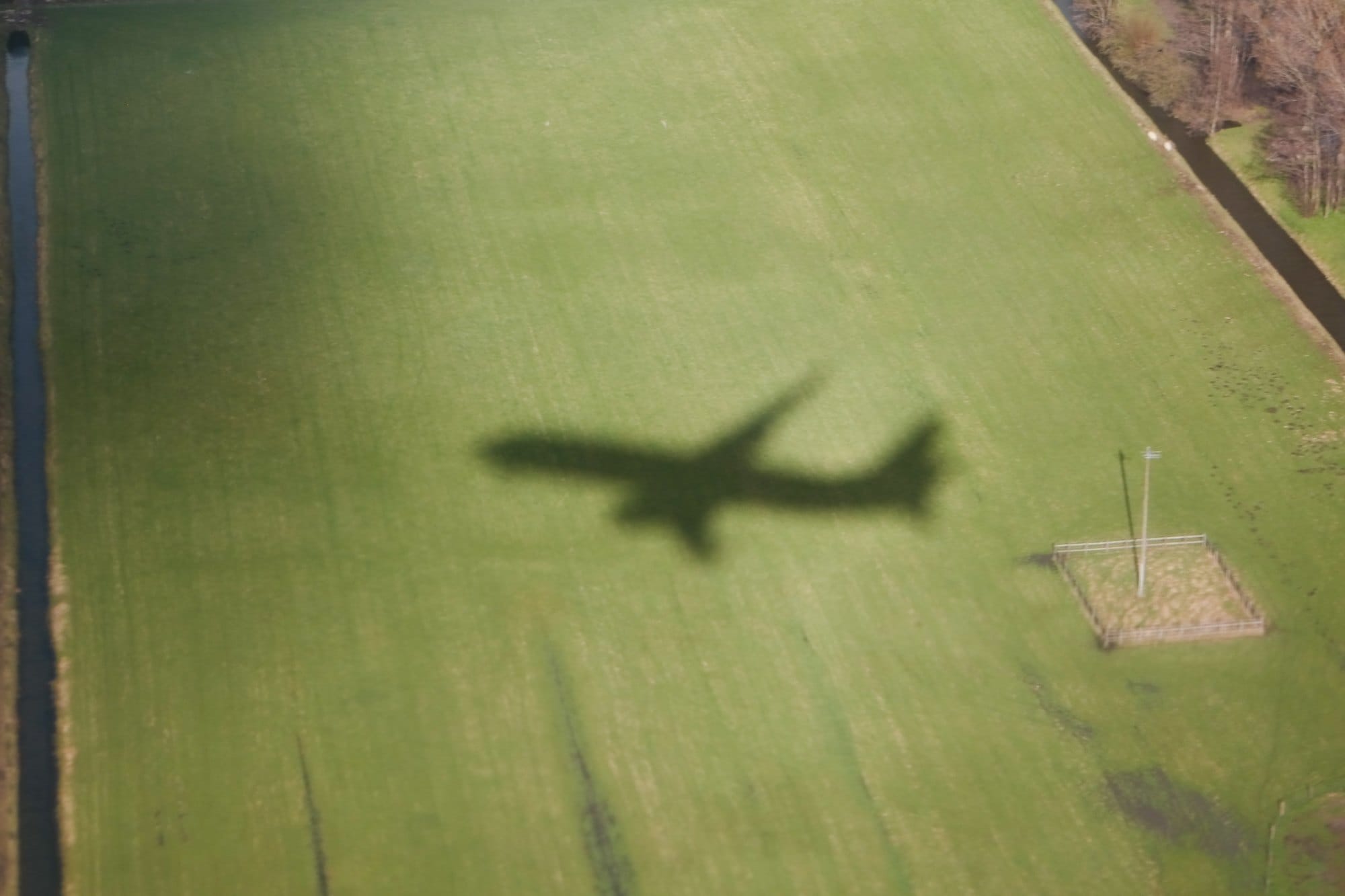 Airplane Shadow Over Large Grassy Agricultural Field