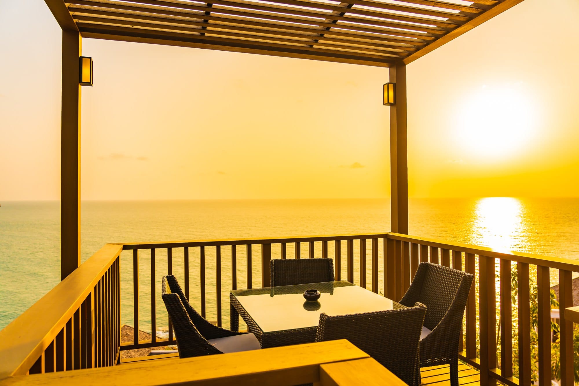 Beautiful outdoor patio with chair table around sea ocean at sunset or sunrise