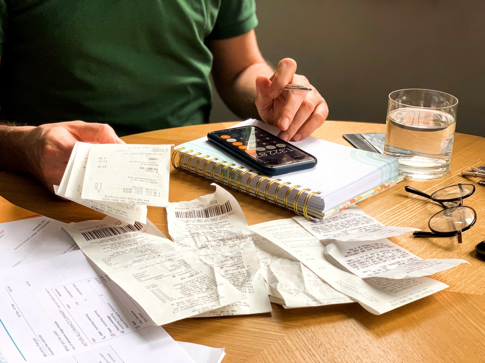Bills, Calculator, and Receipts on Wooden Table