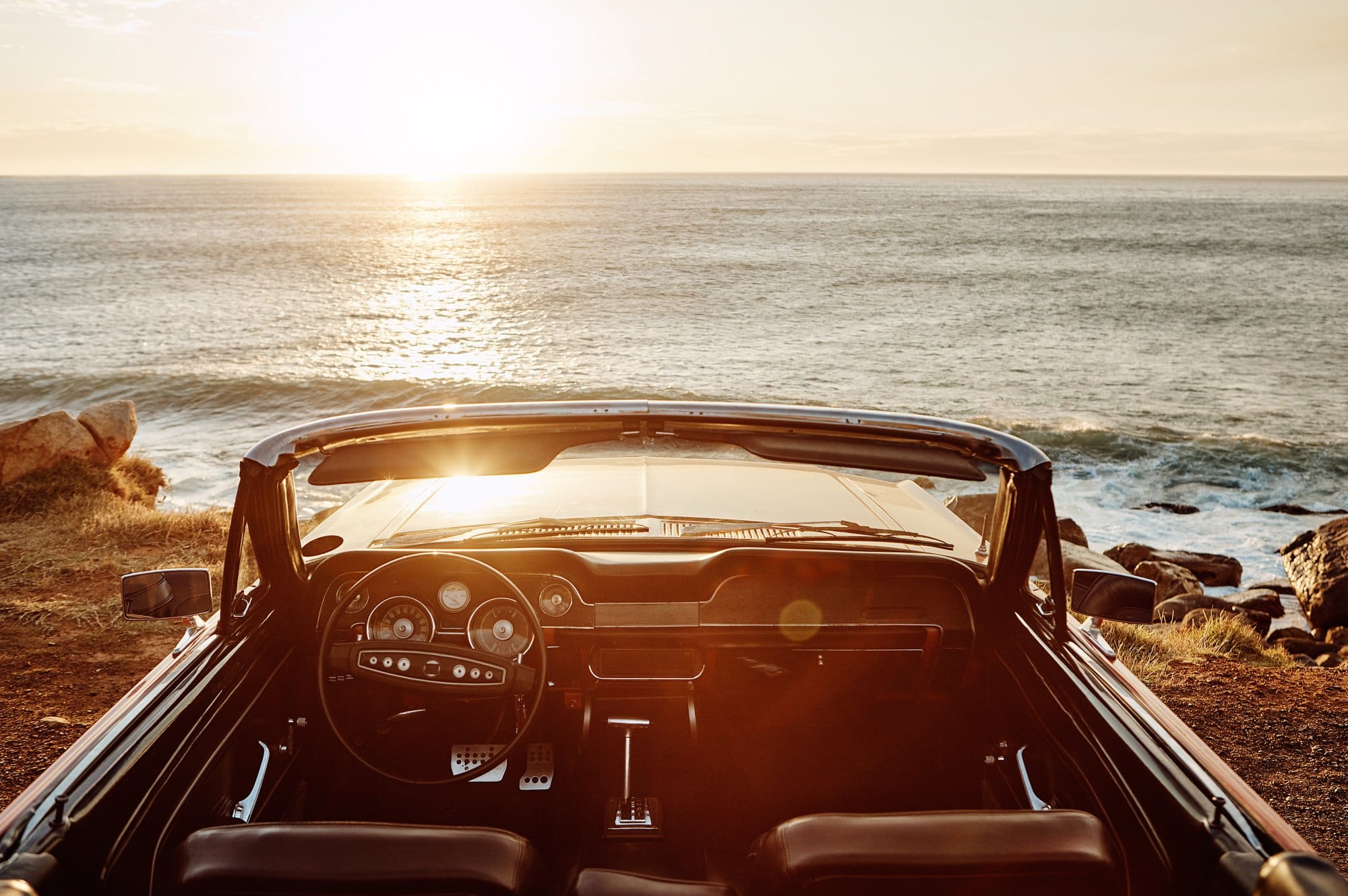 Classic Convertible Car Overlooking the Ocean at Sunset