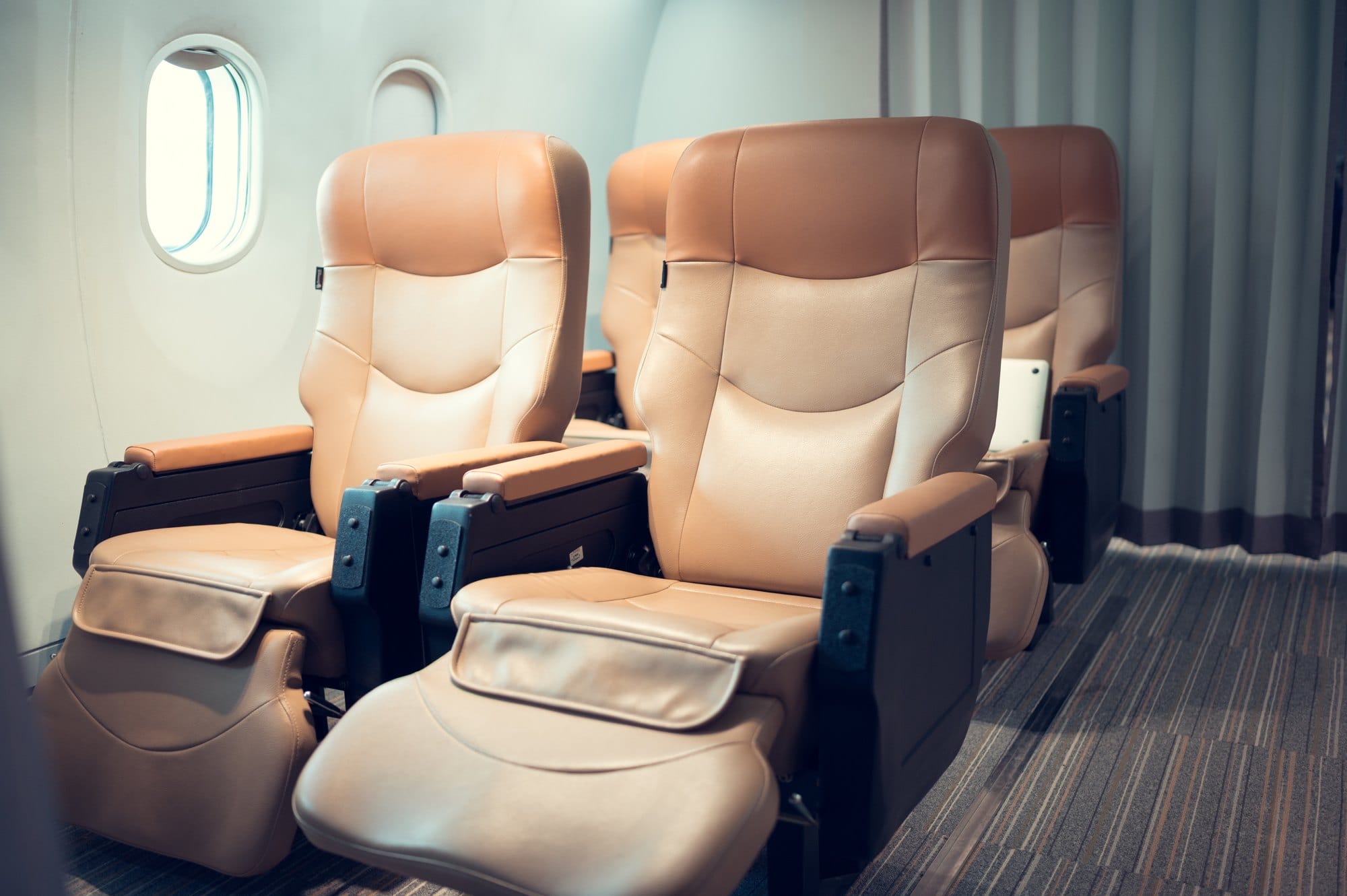 Empty Tan Leather Airline Seats with Window View