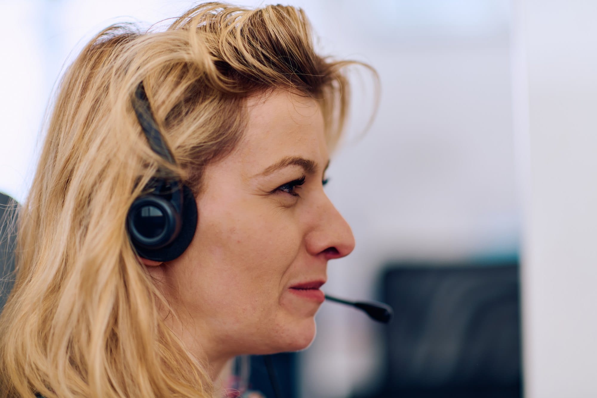 Friendly Call Center Agent Answering Incoming Calls with Headset Providing Remote Customer Service
