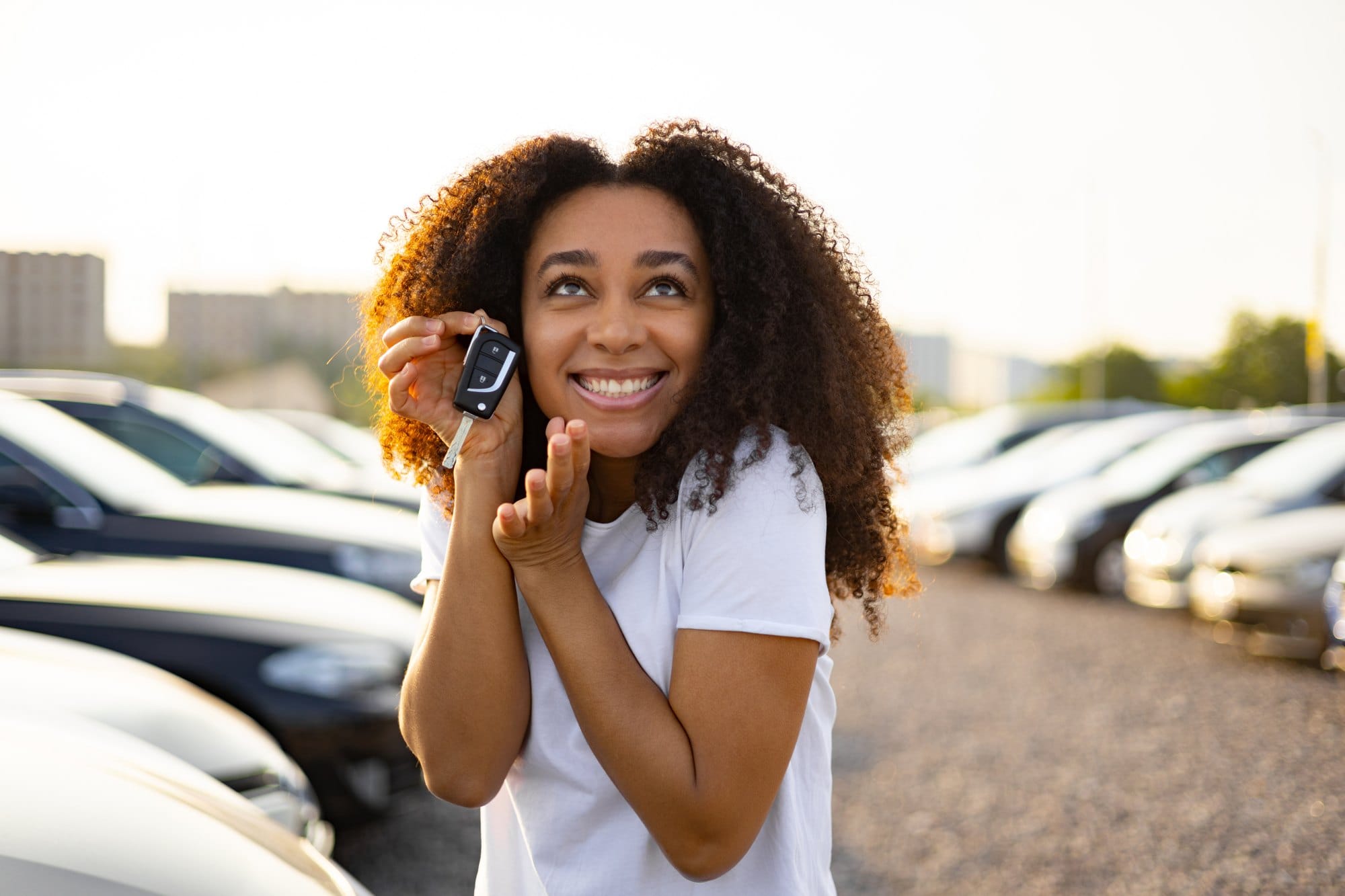 Happy Woman Holding Car Keys Outdoors in Parking Lot