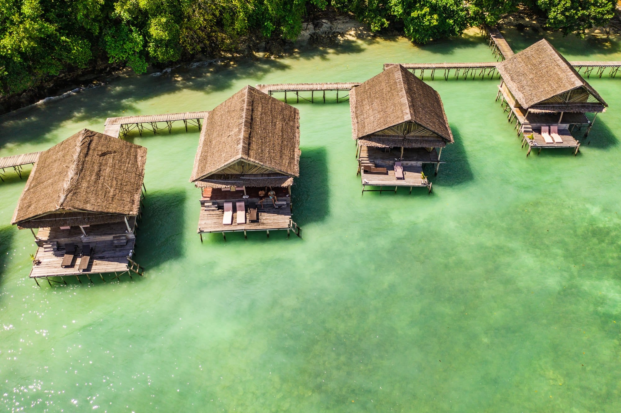 High angle shot of the overwater bungalows along the coast of the Raja Ampat Islands in Indonesia