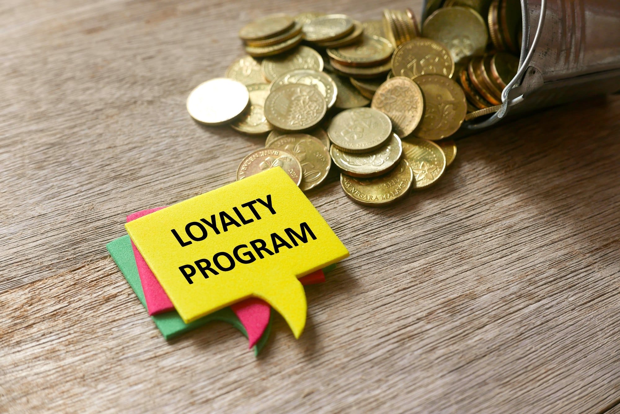 Loyalty Program Concept with Coins on Wood Surface