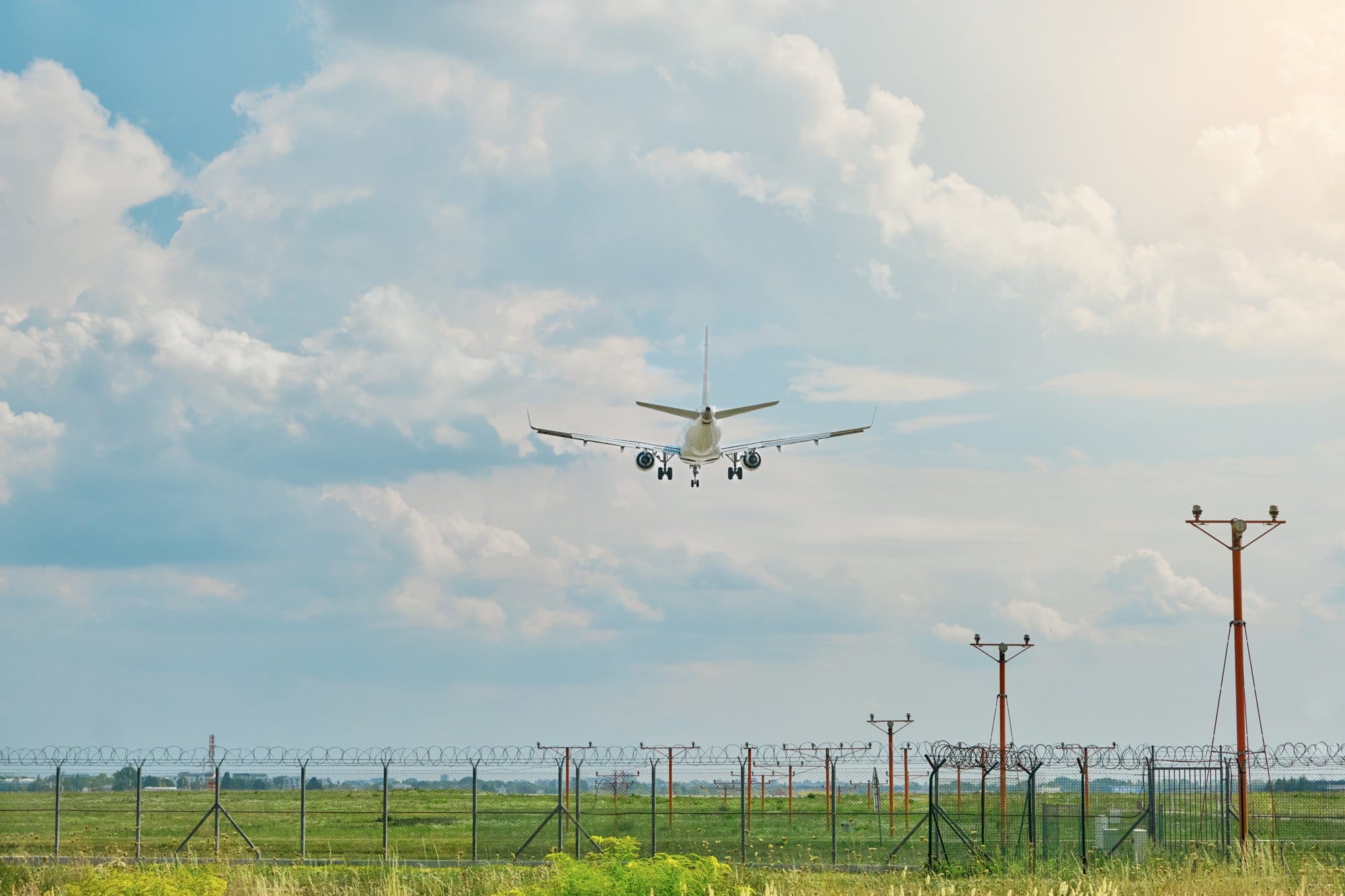 Passenger airplane landing on airport runway during on sunny day. Travel background. Business