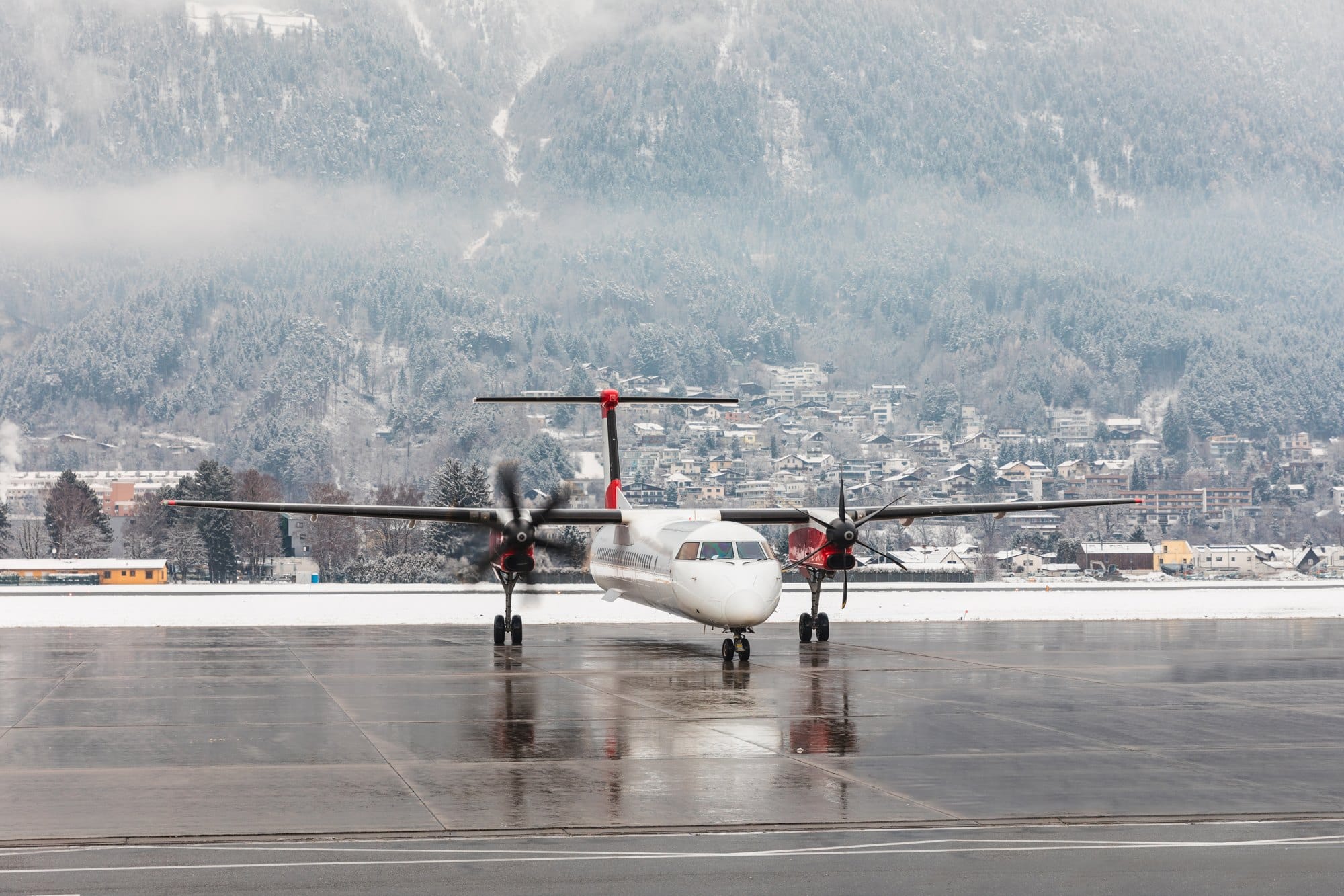 Passenger Airplane on Runway with Snowy Mountain Backdrop