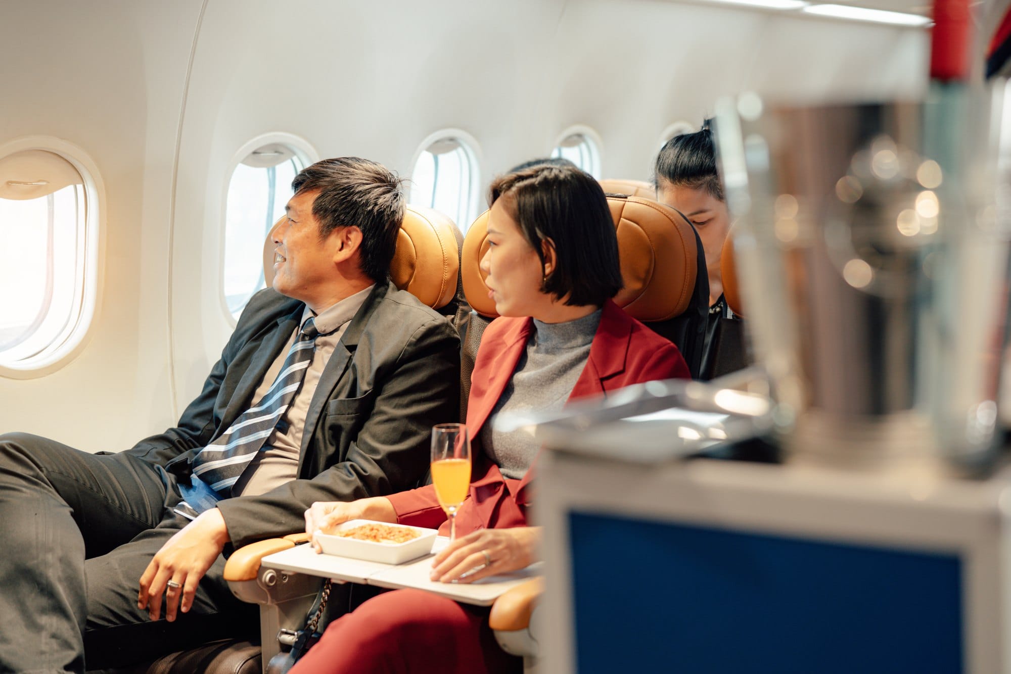 Passengers Enjoying Food and Drinks on Airplane