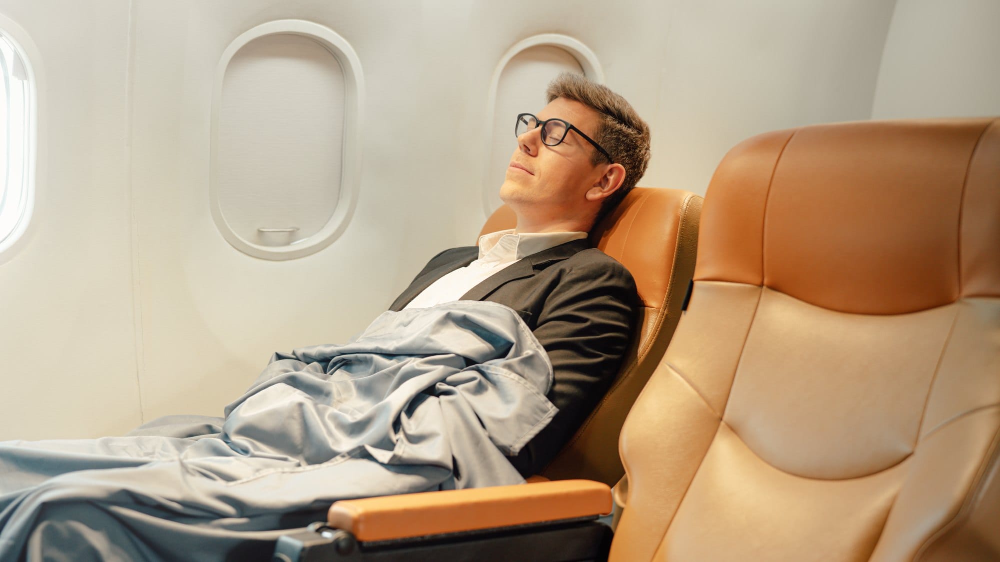 Relaxing Business Traveler Sleeping Comfortably on Airplane