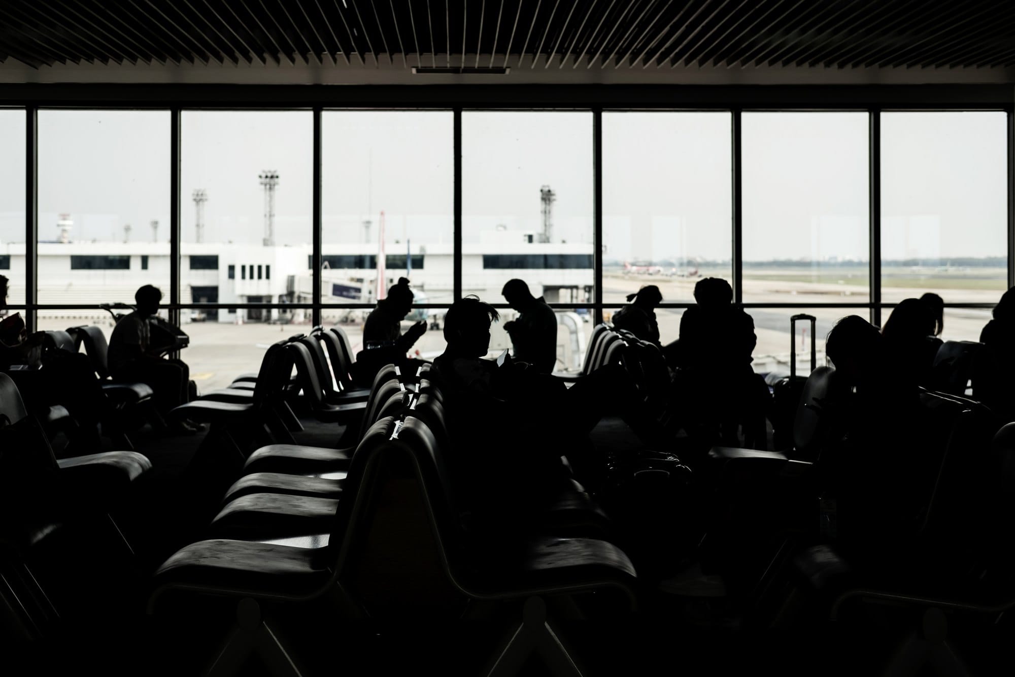 Silhouette of passangers waiting for the flight at the airport