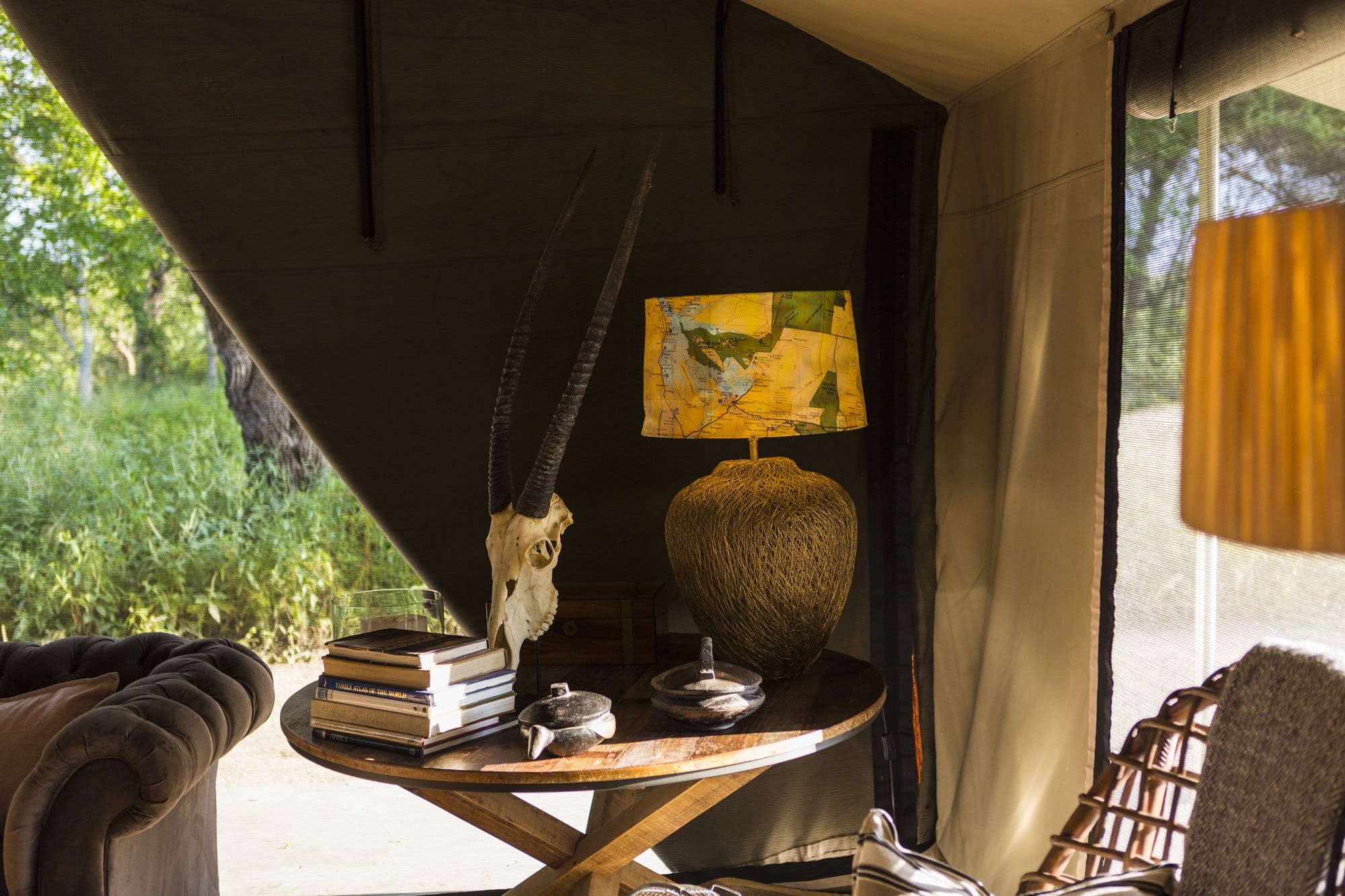 The interior of a tent in a safari camp, tent sides rolled up
