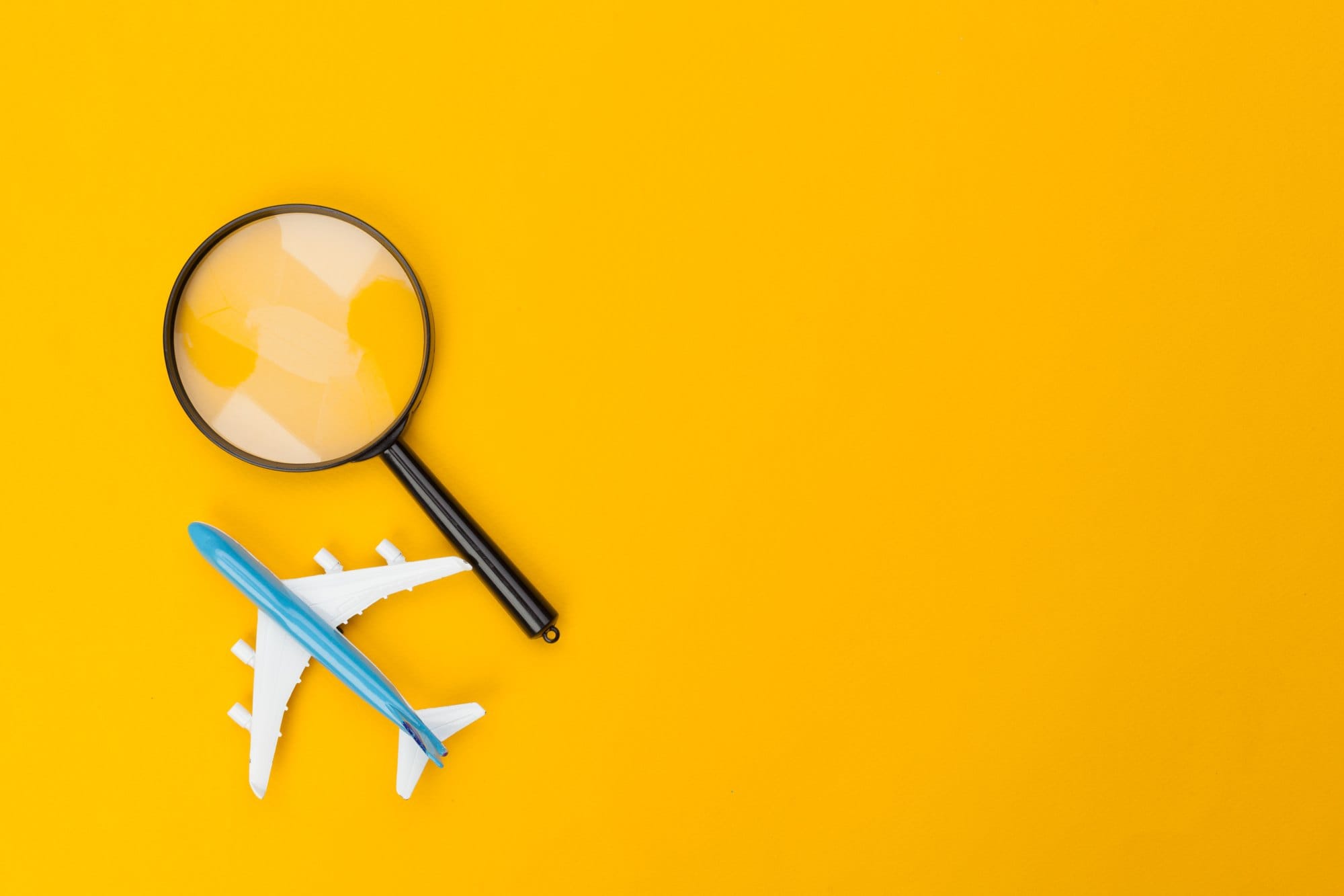 Toy Airplane Under a Magnifying Glass on Yellow