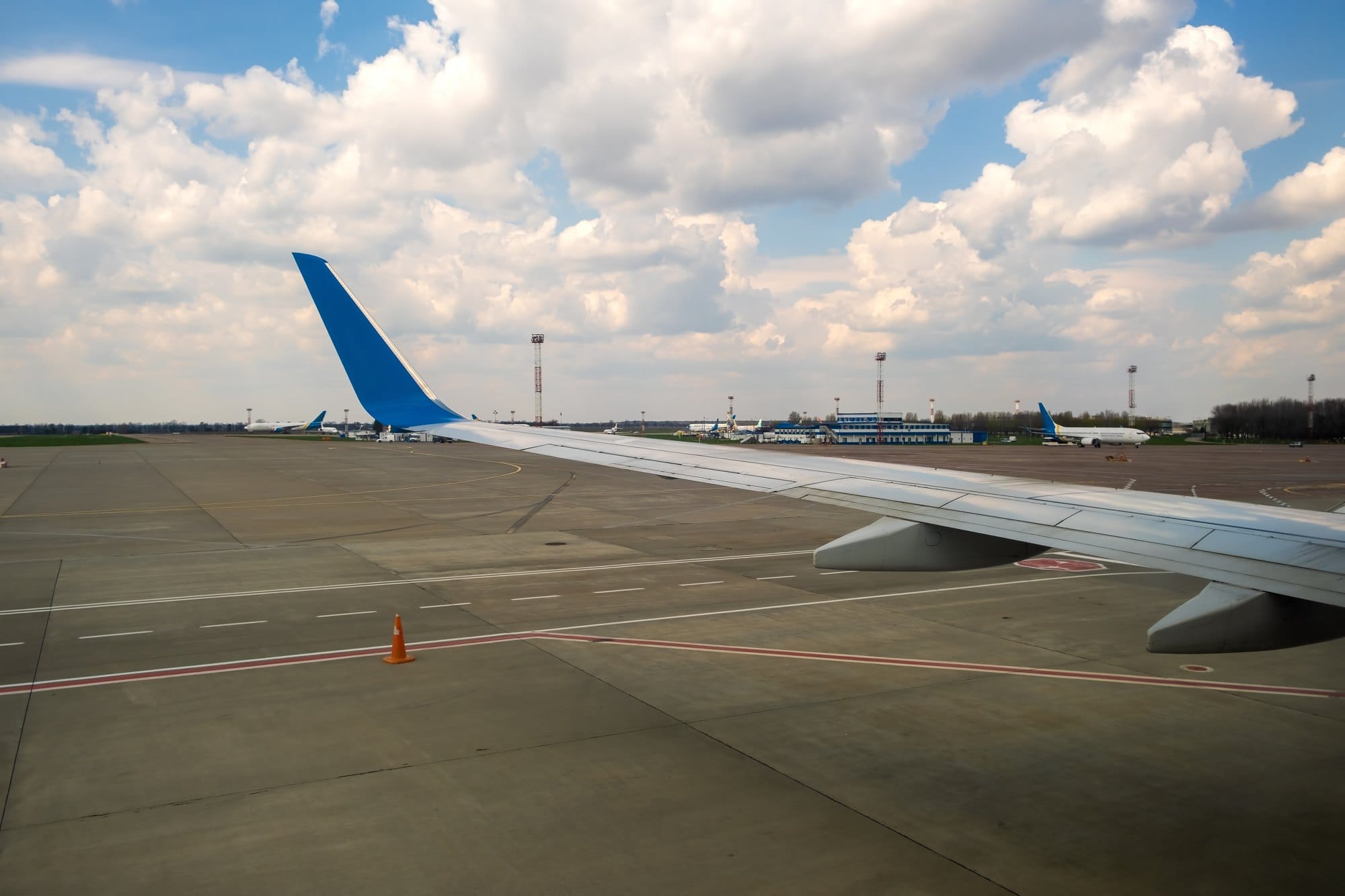 View of jet airplane wing taxiing runway after landing at airport. Travel and air transportation