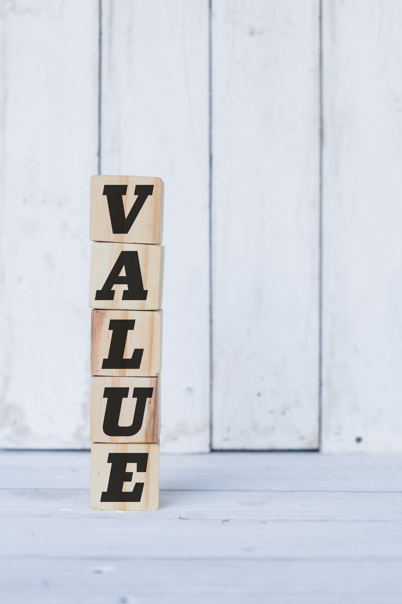 Wooden Blocks Spell Value Against White Wood Backdrop