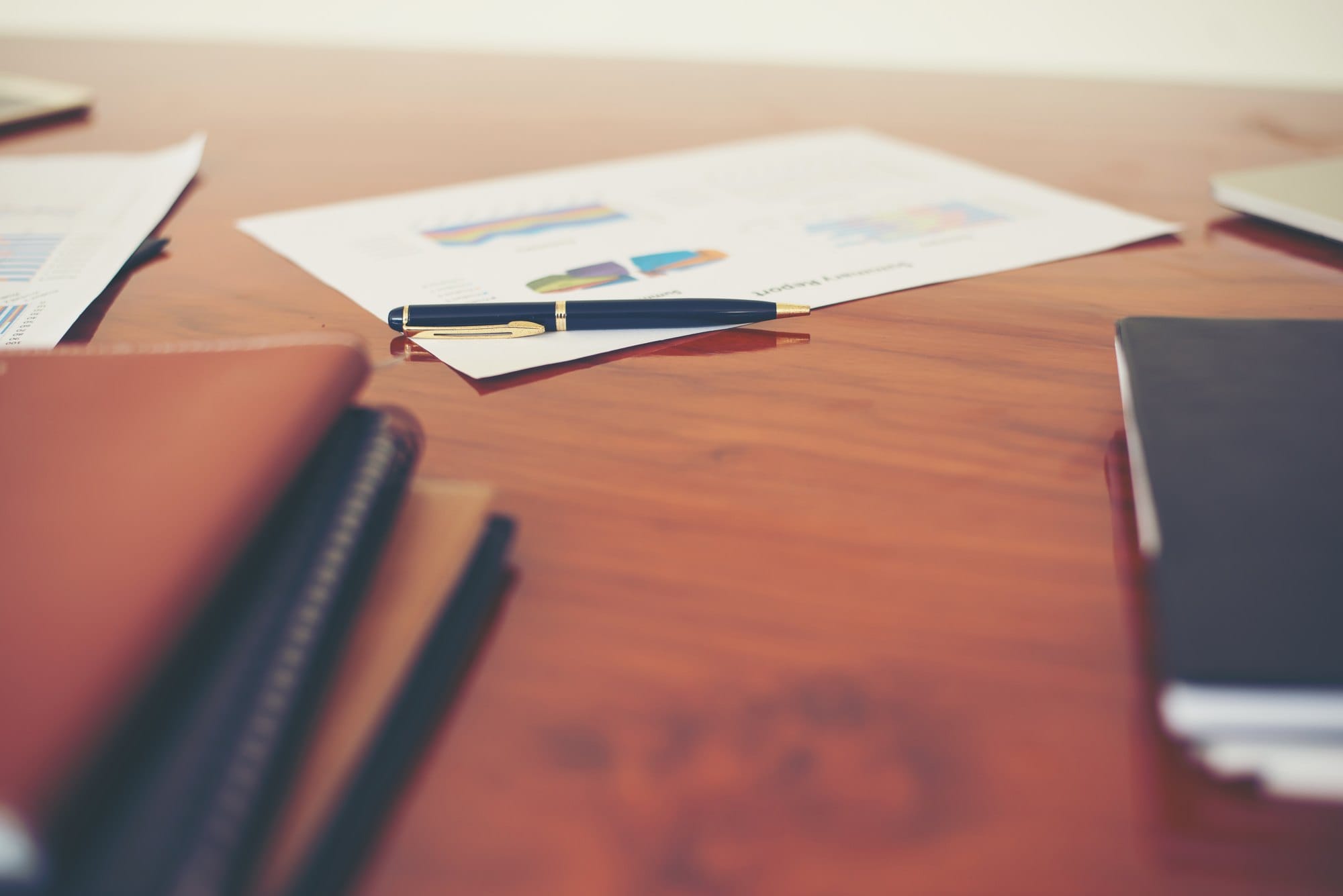 Workplace Desk with Business Report and Pen
