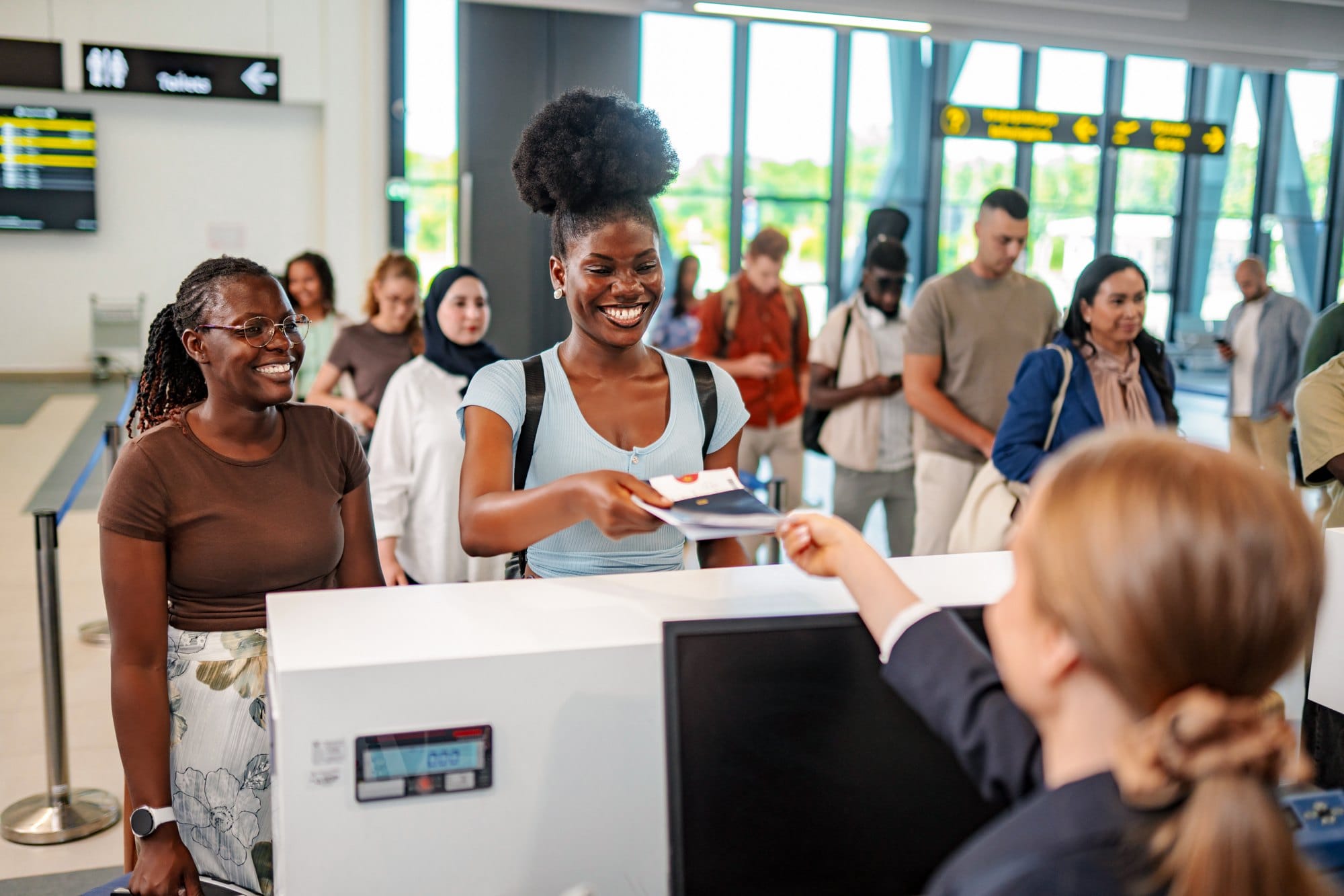 Young adult woman checking in at airport counter