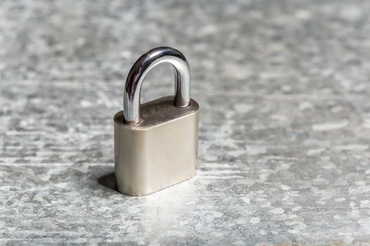 Silver Padlock on Textured Gray Surface Close-Up