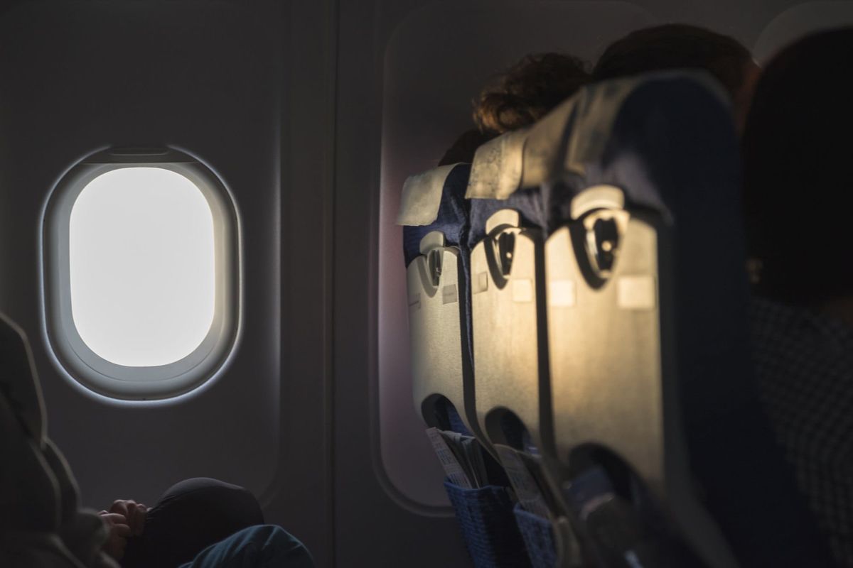 Passengers Sit in Plane near Airplane Window