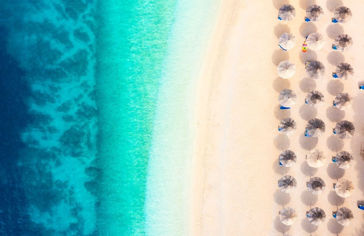 Aerial view on beach and umbrellas. Vacation and adventure. Top view from drone