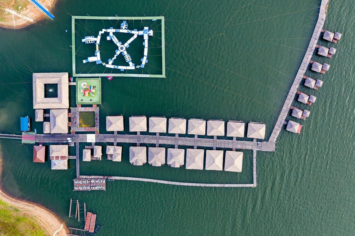 Wooden raft resort with water park floating on dam