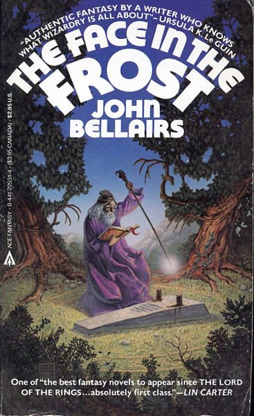 "The Face in the Frost" by John Bellairs. A purple robed wizard stands over a grave in a forest, casting a spell with a tome in one hand and a staff in the other. The whole image screams WIZARDRY.