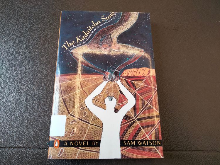 Cover depicting an Aboriginal figure reaching from the sky to a white silhouette or shadow on a desert landscape