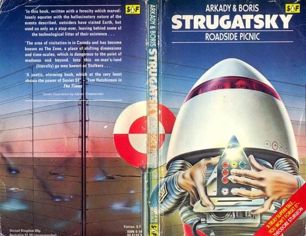 Cover of "Roadside Picnic". A guy in a weird egg-shaped spacesuit holds a strange mechanical device.