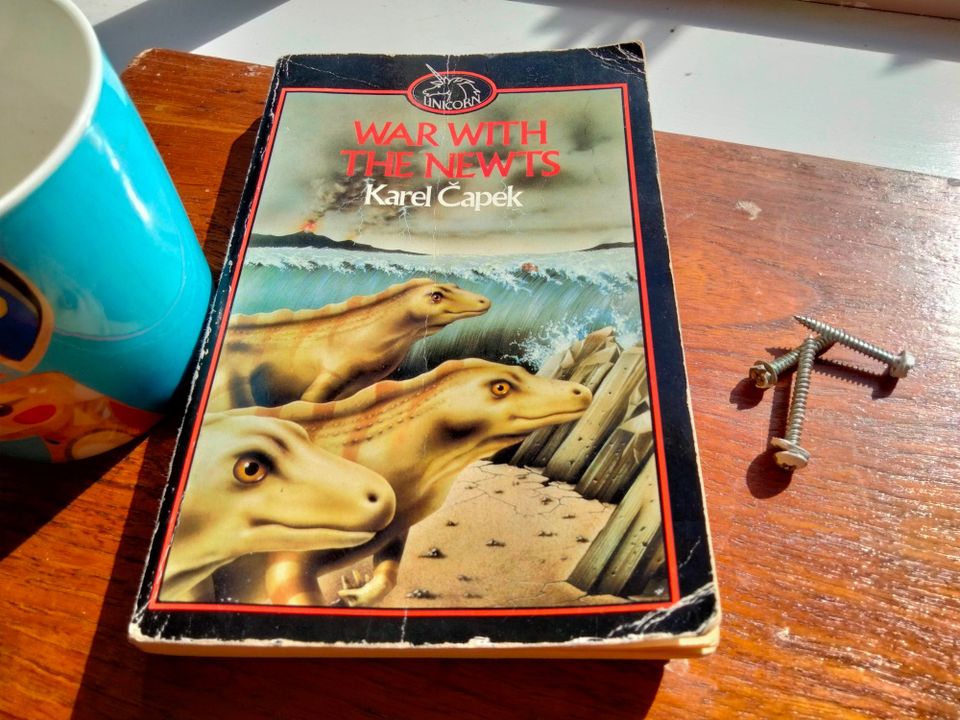 Book cover with greenish salamanders in front of a tidal wave and a volcano