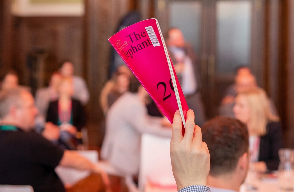 Szene auf dem Festival 2026: Eine Hand hält ein Exemplar des Journals "The Elephant" in die Höhe