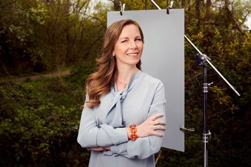 Stefanie Hauer steht vor einer Leinwand in einem Garten.