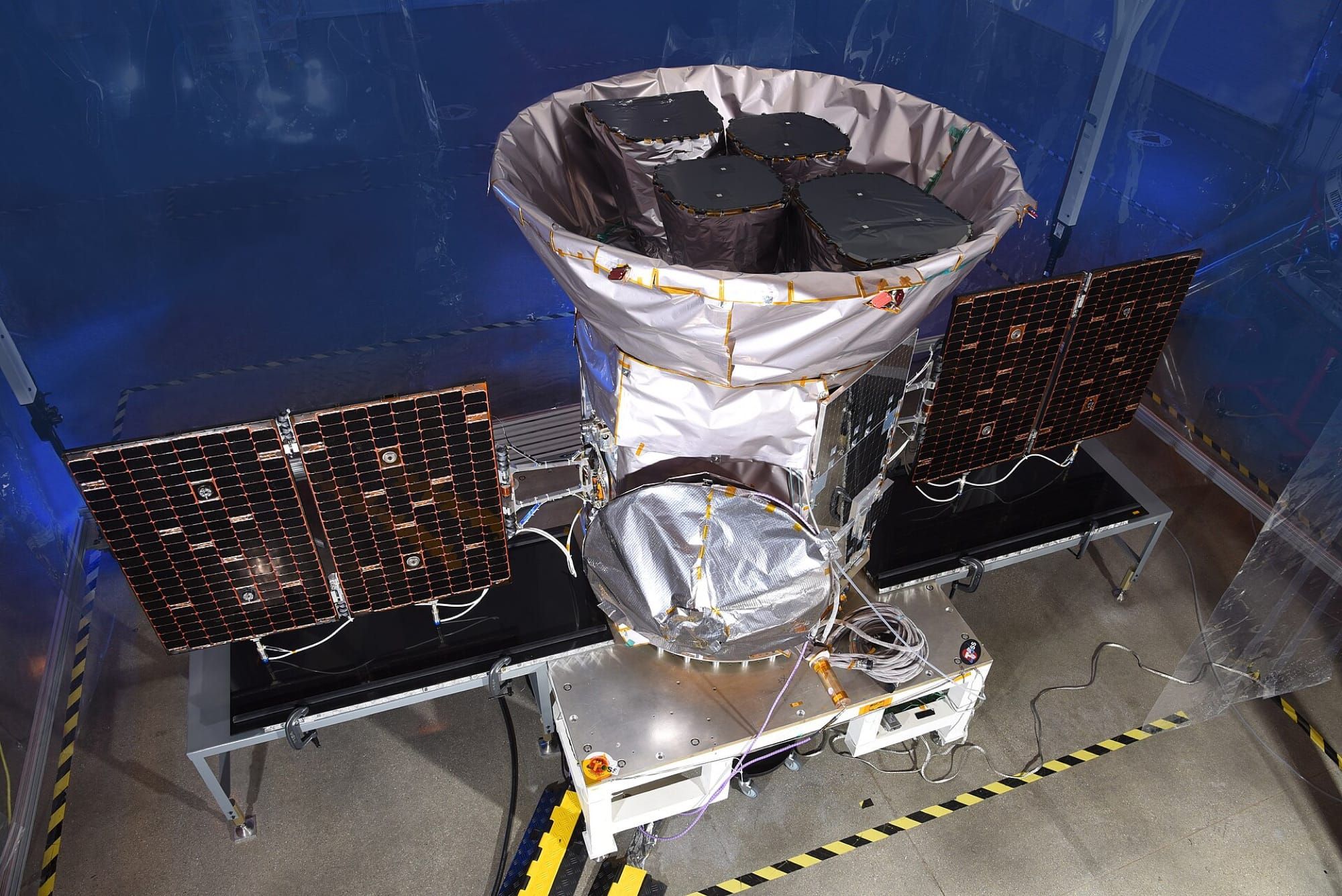 Satelitul TESS al NASA, cu panourile solare desfăcute, într-o cameră curată înainte de lansare