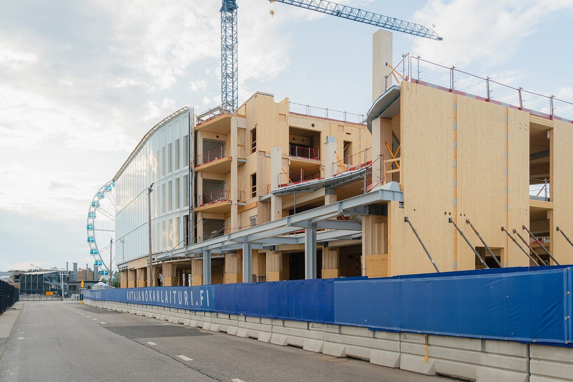 Clădire din lemn masiv în construcție, cu panouri CLT vizibile și macara