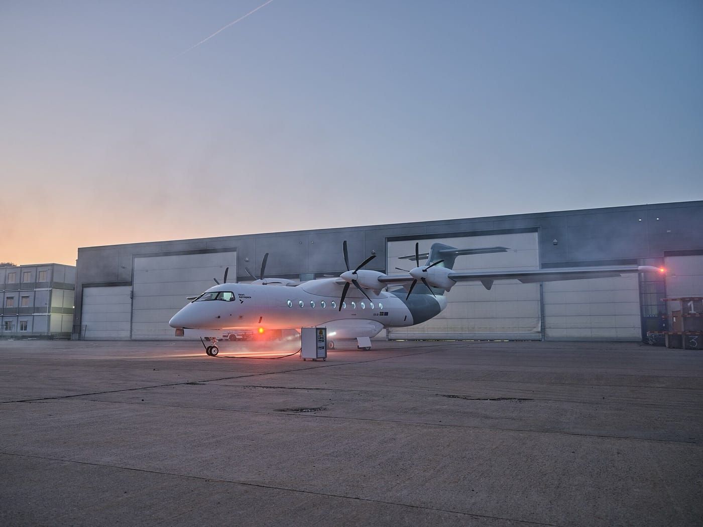Demonstratorul electric Heart Aerospace X1 pe platforma unui aeroport, la asfințit