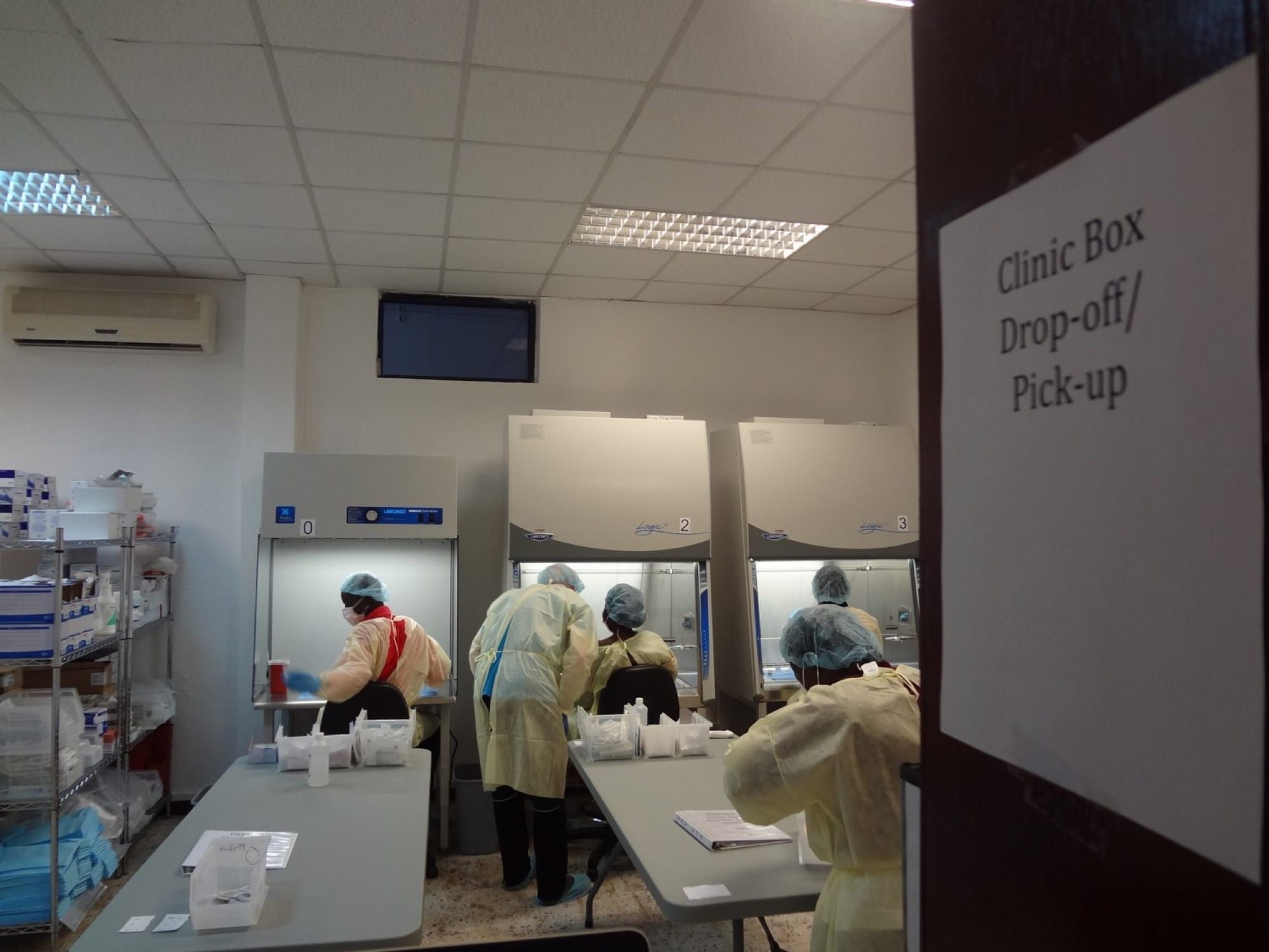 Lucrători medicali în echipament de protecție într-un laborator care procesează probe, în contextul cercetării vaccinulu