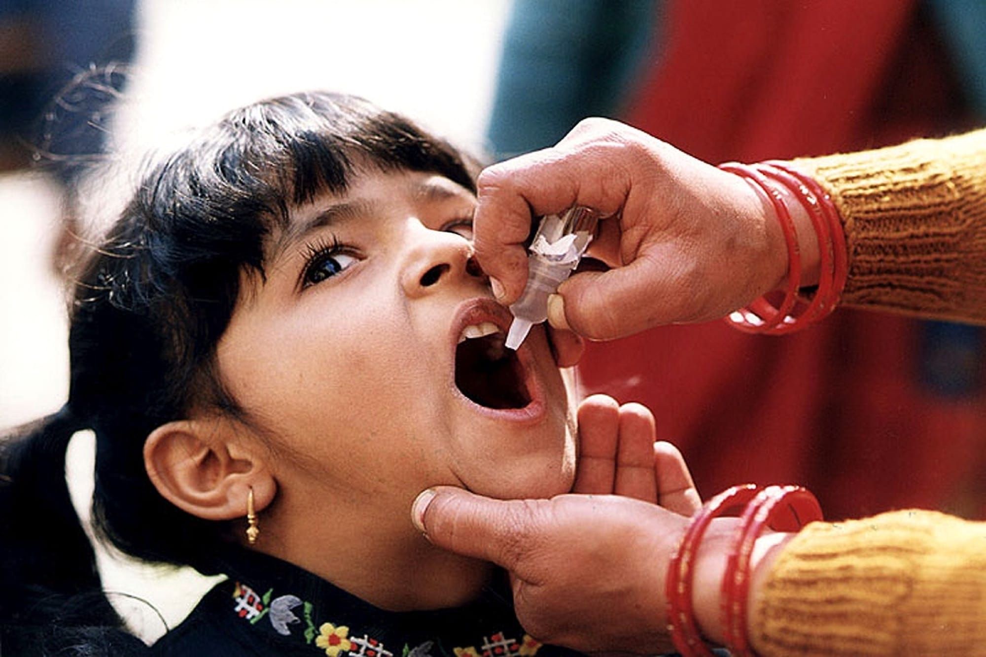 Copil primind vaccin oral anti-poliomielită, imagine ilustrativă a campaniilor de vaccinare anti-polio