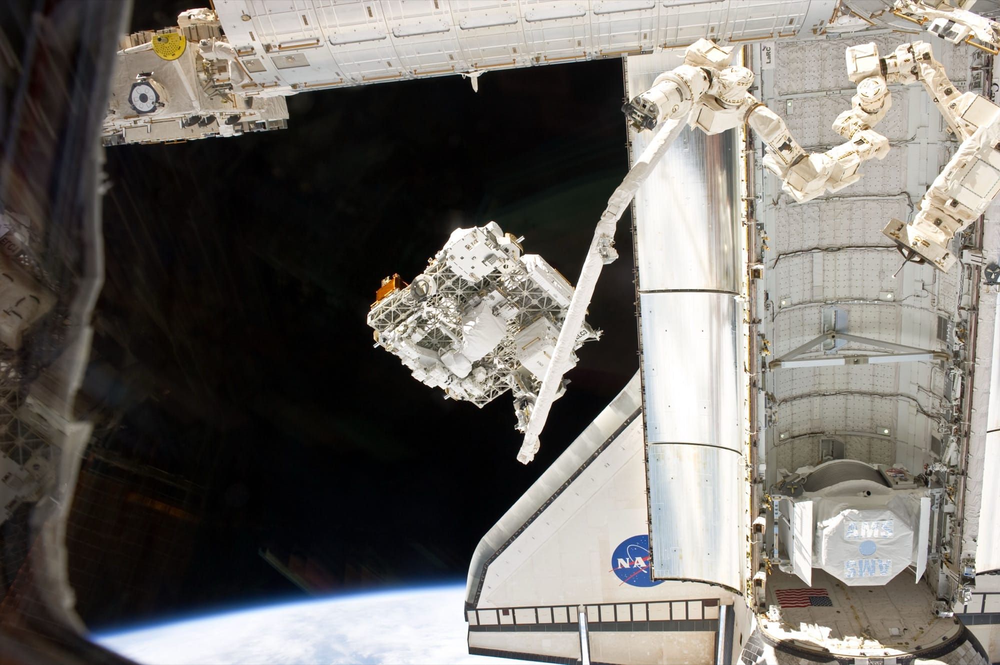 Brațul robotic Canadarm al navetei Endeavour manevrând o structură în spațiu