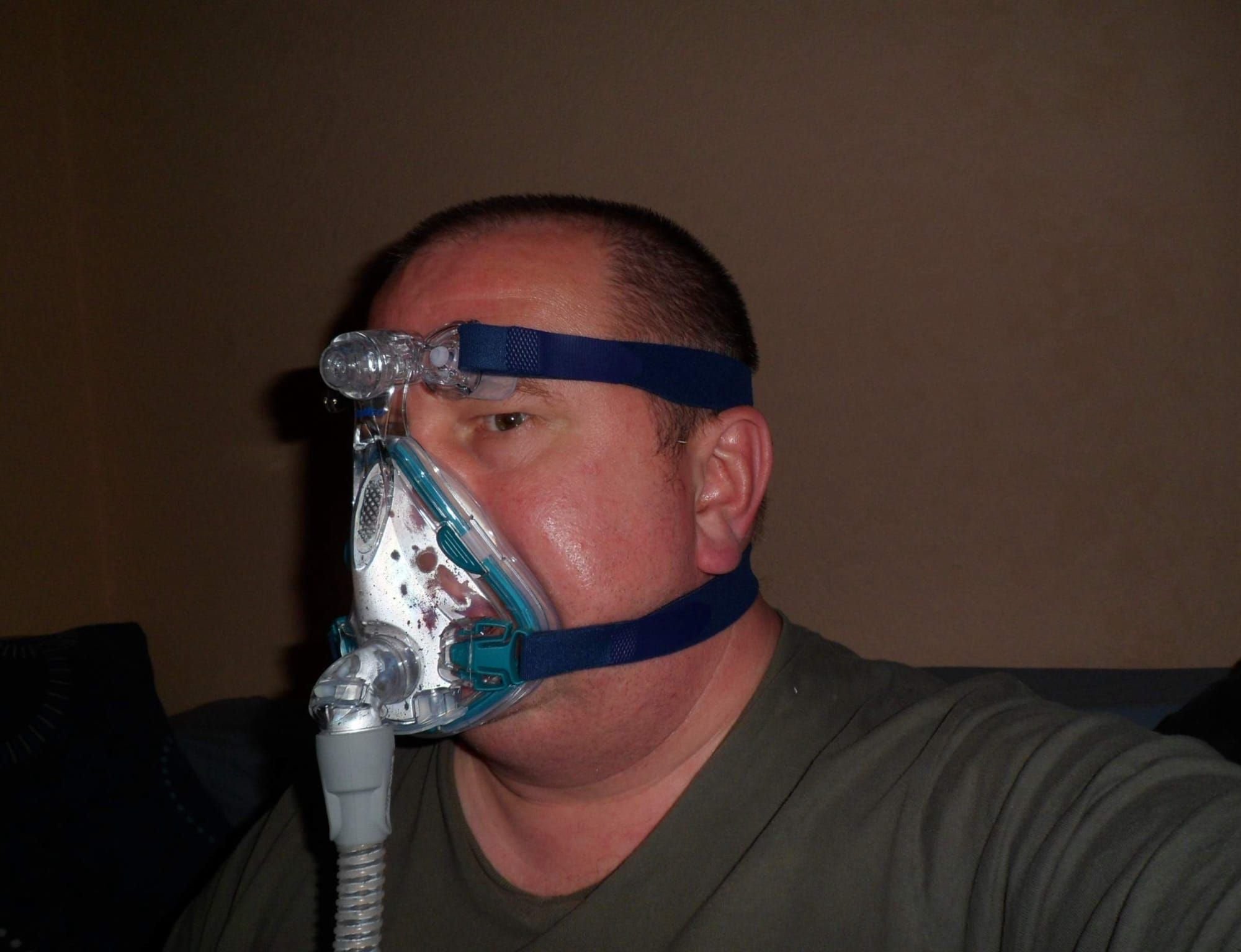 Bărbat purtând o mască CPAP pentru apnee în somn