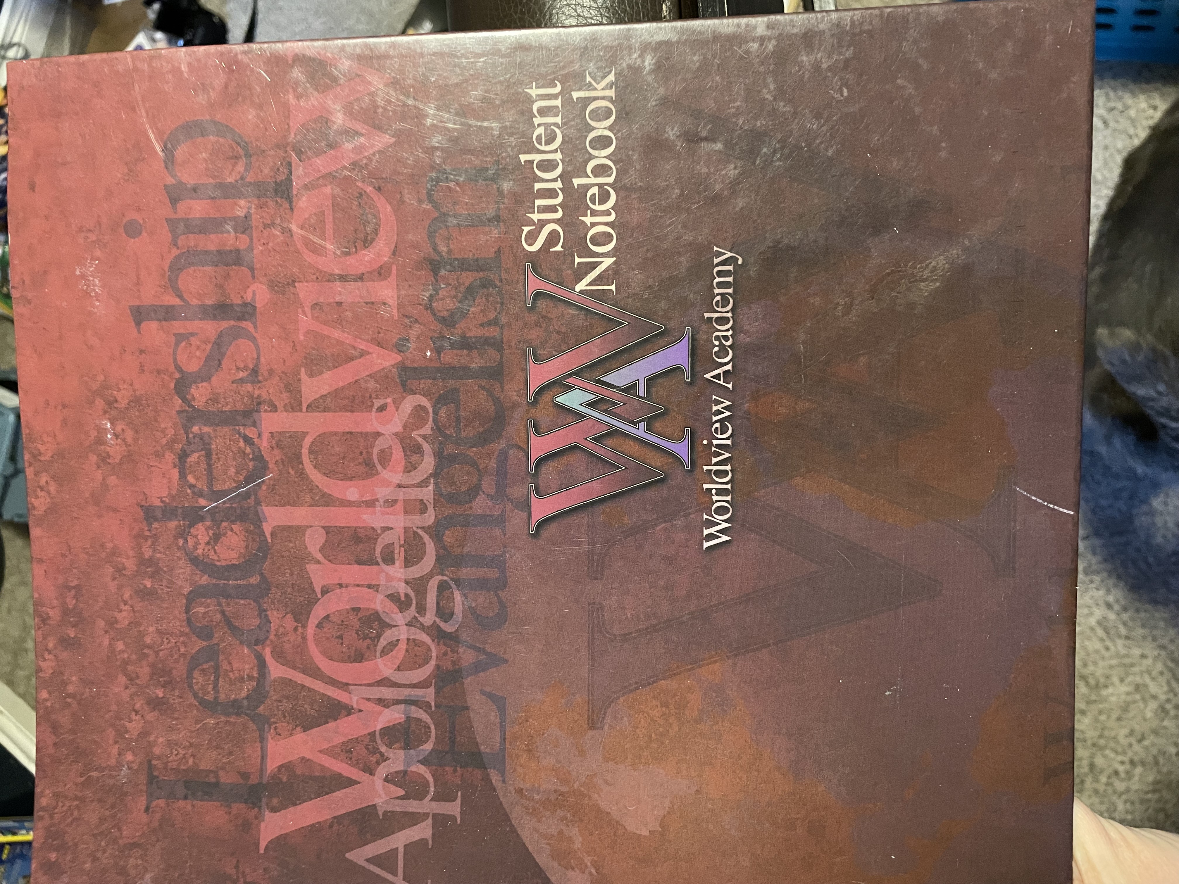 red distressed workbook cover that says leadership worldview apologetics evangeliclaism wordlveiw acadamy student notebook
