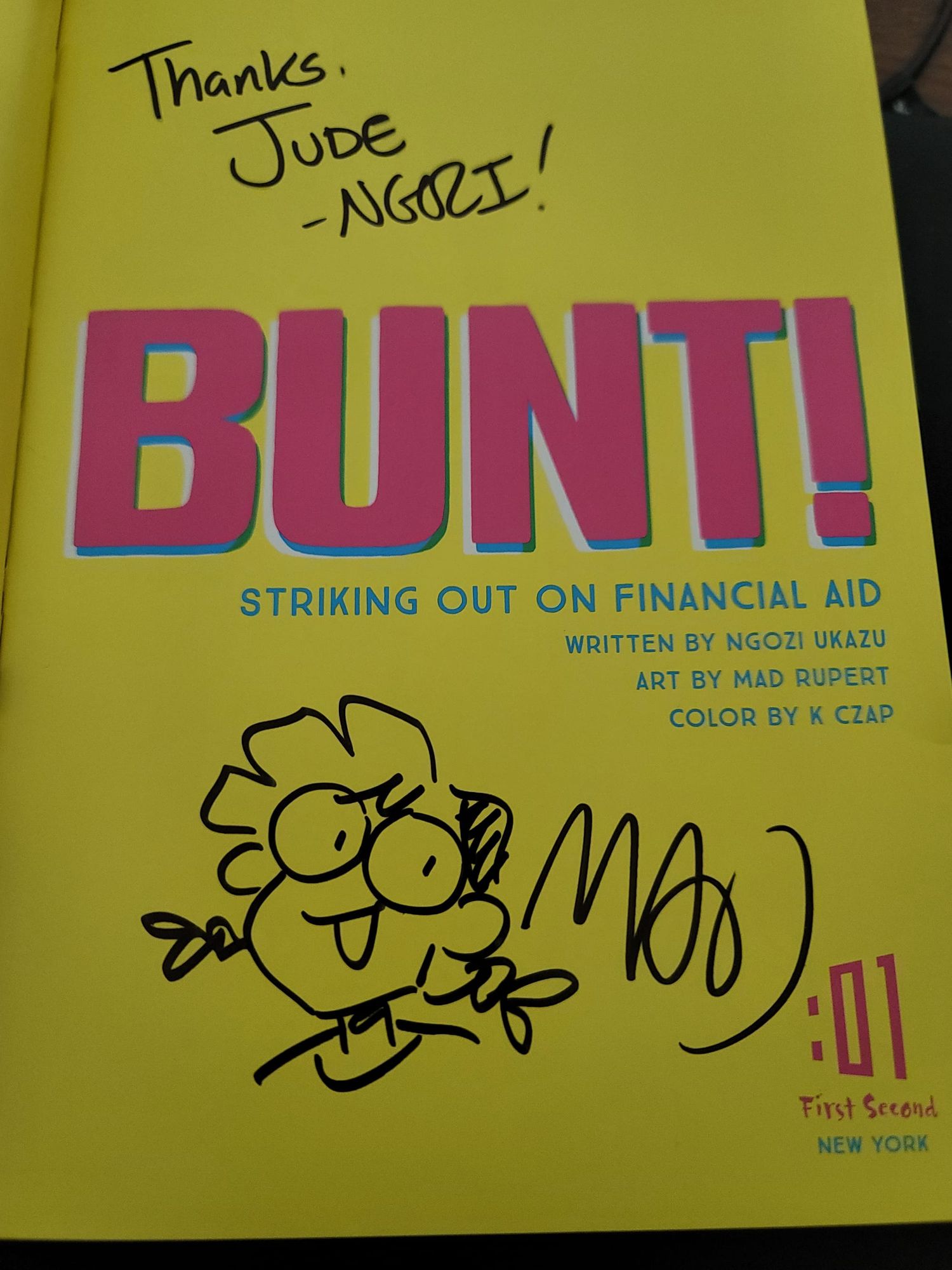 The inside cover of the comic "Bunt! Striking Out on Financial Aid". Mad Rupert drew a doodle of the protagonist and signed her name, Ngozi Ukazu wrote "Thanks, Jude -Ngozi!