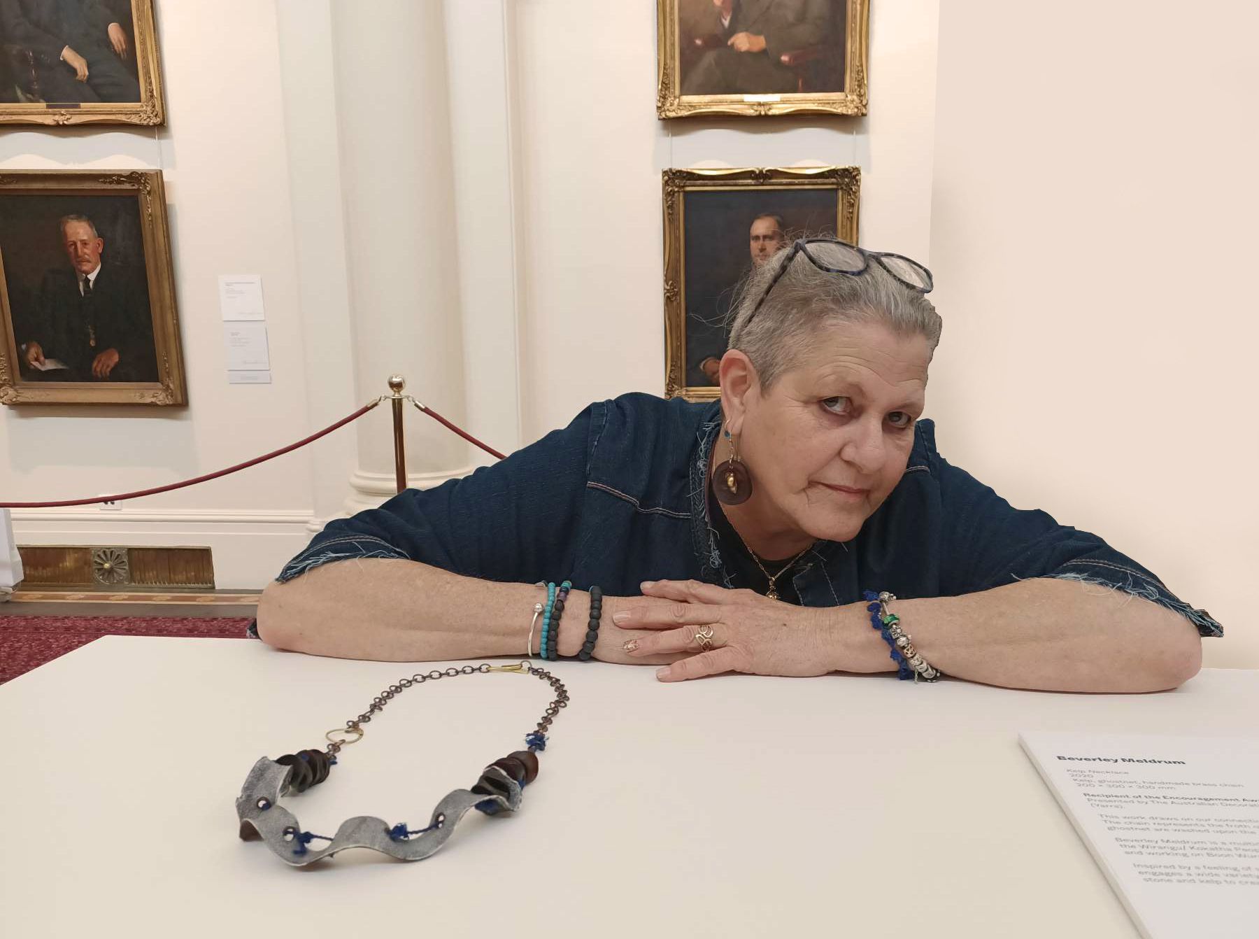 Beverley Meldrum leans on a table next to her kelp jewellery and biography.