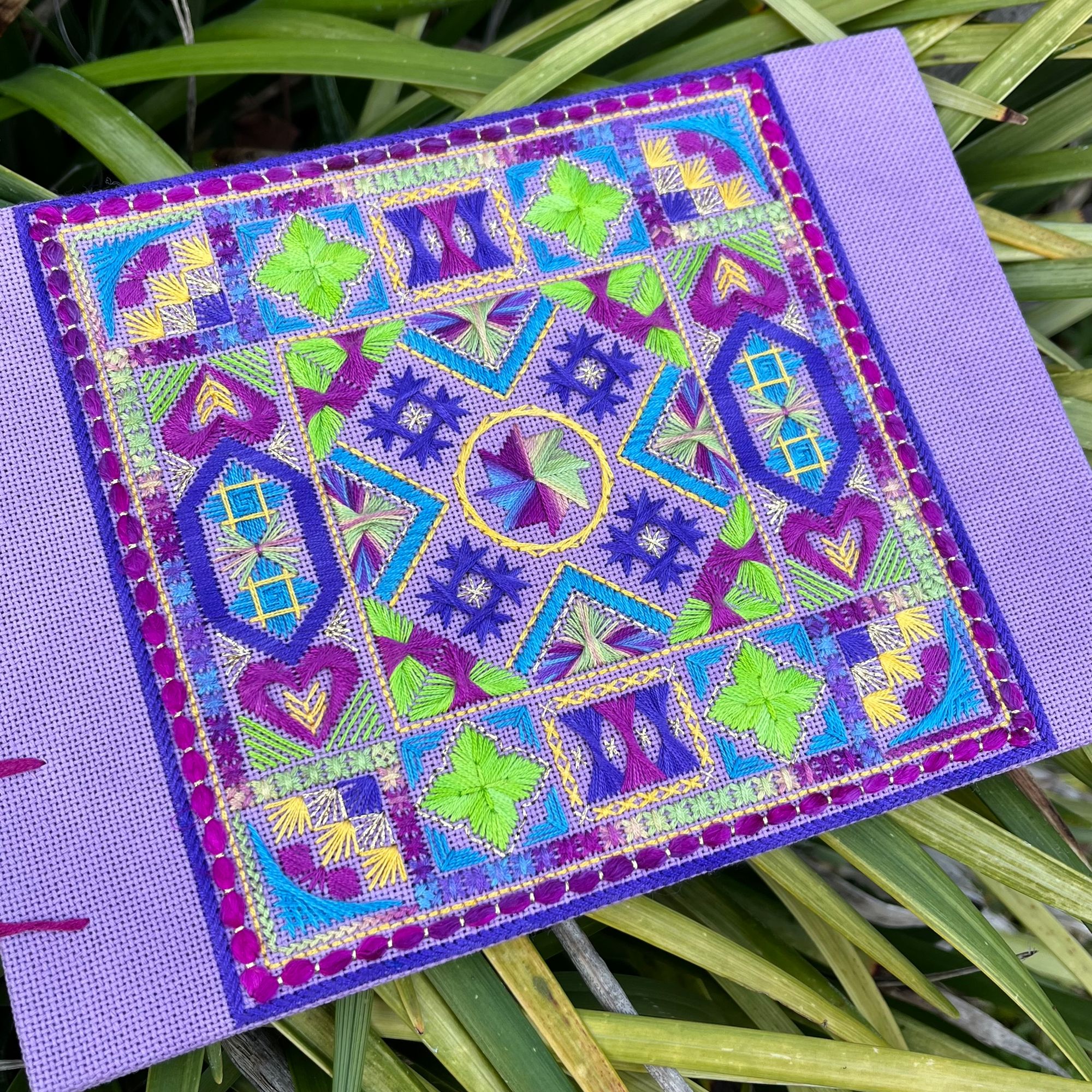 Stitching a detailed pattern on a canvas.