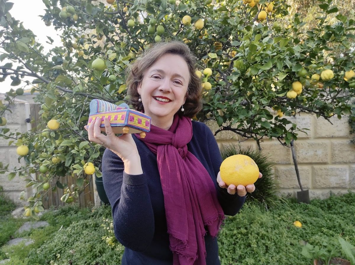Ann-Marie Anderson-Mayes standing in her garden with a lemon tree behind her.
